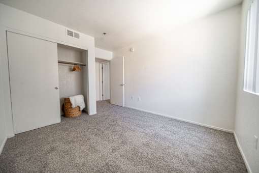 A room with a carpeted floor and a white door.