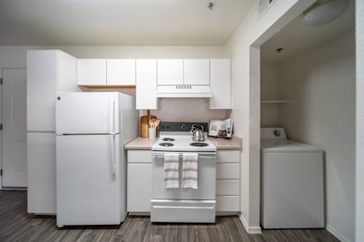 A white kitchen with a refrigerator, stove, and oven.
