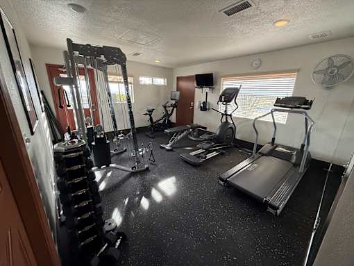 A spacious home gym with a variety of exercise equipment.