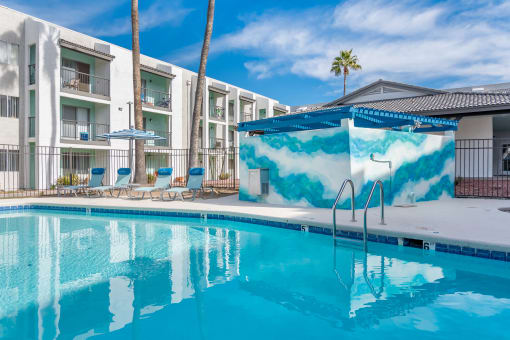 a swimming pool with a white building in the background