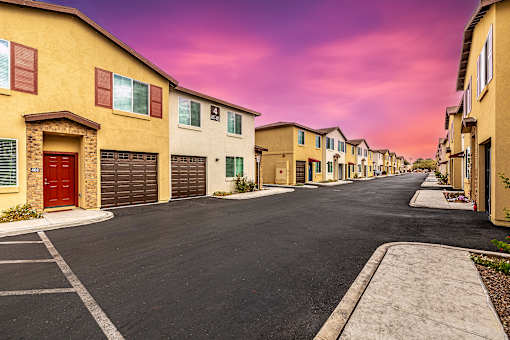 A row of houses with garages and driveways.