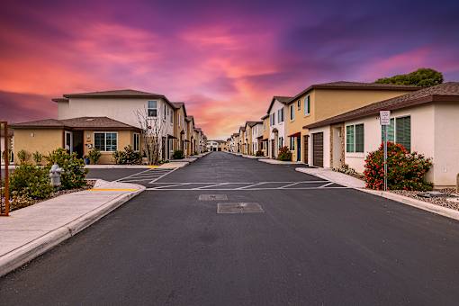A street in a residential area with houses on both sides.
