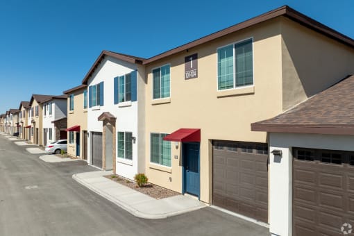 a row of townhomes with cars parked in front of them