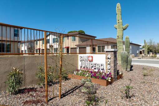 a building with a sign and a cactus in front of it