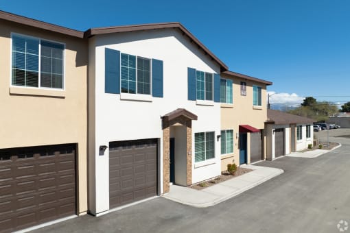 a house with two garage doors and a street in front of it