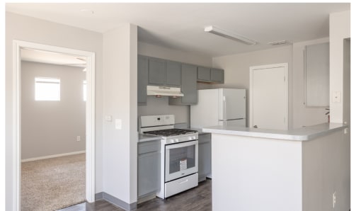 an empty kitchen with white appliances and a white counter top