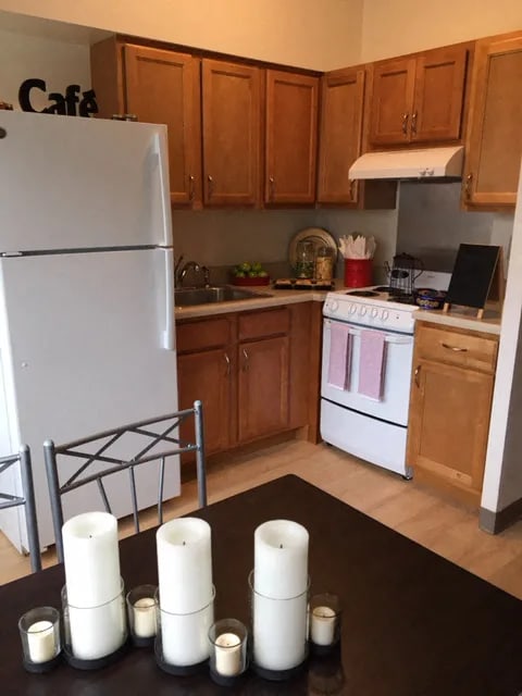 Candles are on a table in a kitchen.