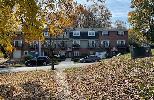 A residential area with houses and cars parked on the street.