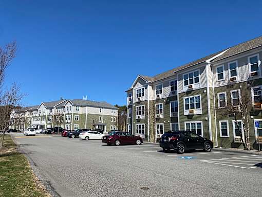 A parking lot with cars and apartment buildings in the background.