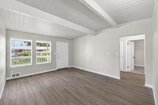 A room with a white ceiling and wooden flooring.