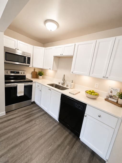A modern kitchen with white cabinets and a black dishwasher.