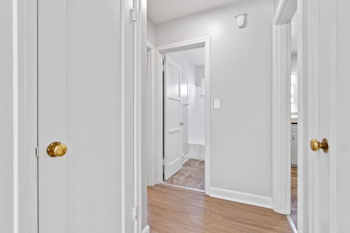 a bedroom with white walls and wood flooring