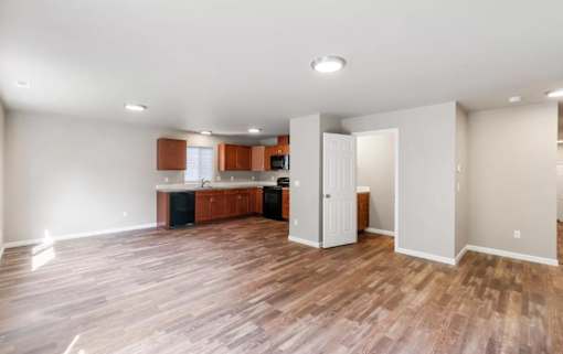 A kitchen with wooden floors and white walls.