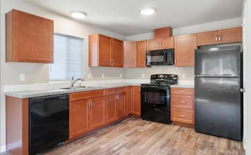 A kitchen with wooden cabinets and black appliances.