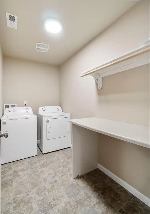 A laundry room with a washer and dryer and a shelf.