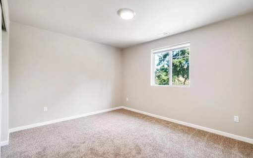 A room with a window and carpeted floor.