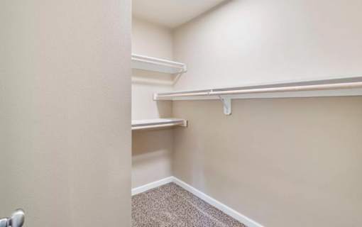 A room with a carpeted floor and a white door.