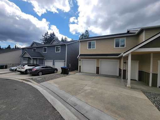 A row of houses with a car parked in front of the first house.