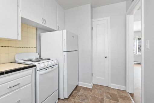 a kitchen with white appliances and white cabinets