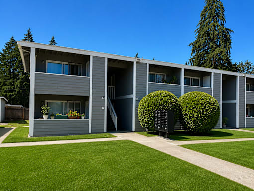 A row of houses with green bushes in front.