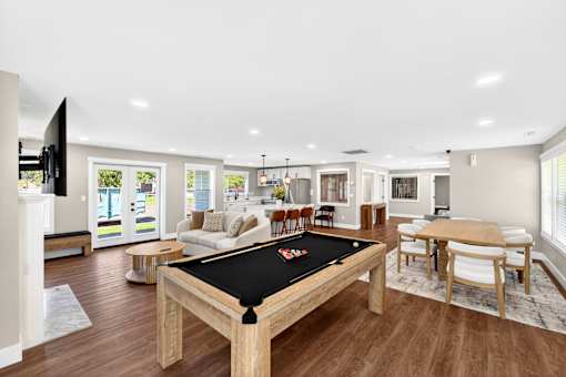 A billiard table is in the middle of a well-furnished room.