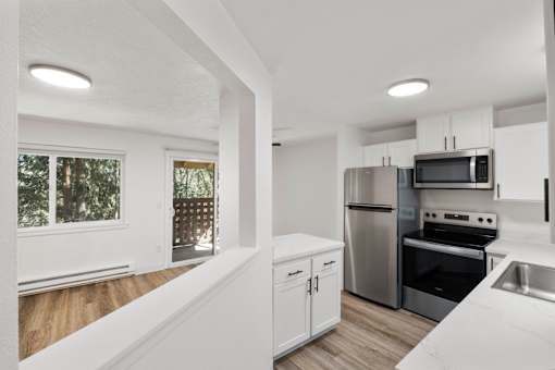 A kitchen with white cabinets and stainless steel appliances.