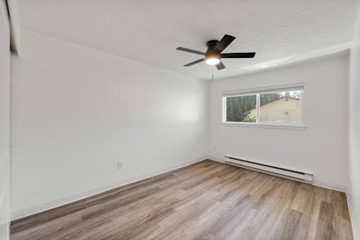A room with a ceiling fan and a window.