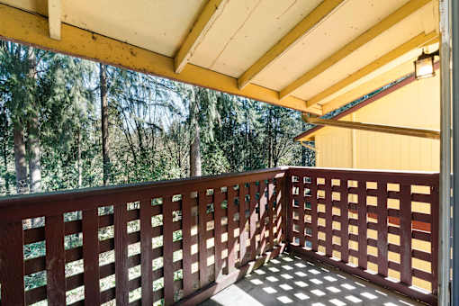 All units have either a balcony or patio overlooking a yard or wooded area.