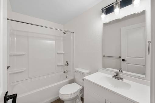 A white bathroom with a toilet, sink, and bathtub.
