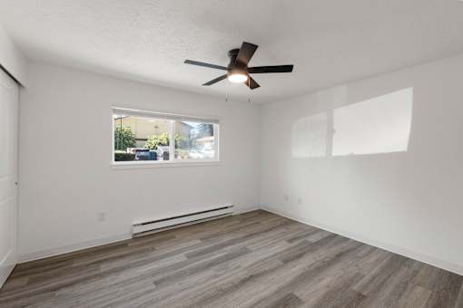 Bedroom with a ceiling fan and a window.