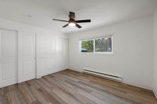 Bedroom room with a ceiling fan and a window.