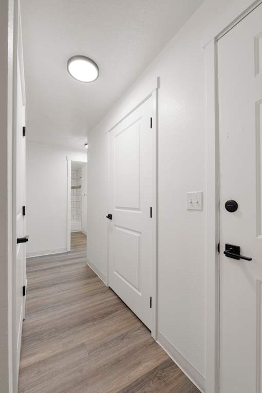 A hallway with white doors and a light on the ceiling.