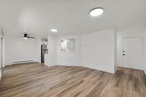A room with wooden flooring and white walls.