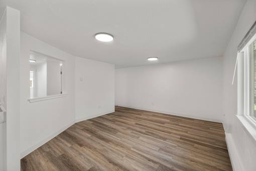 A room with wooden flooring and white walls.