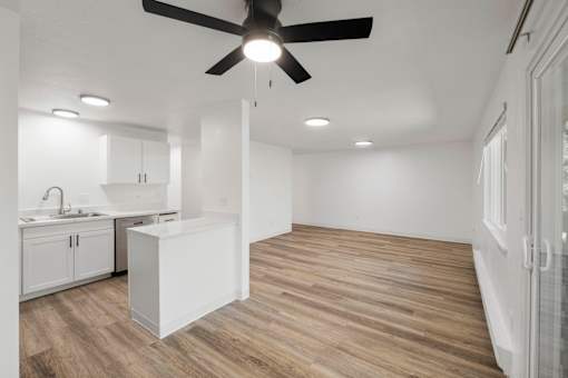 A modern kitchen with a wooden floor and white walls.