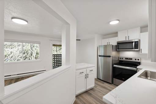 A kitchen with white cabinets and stainless steel appliances.