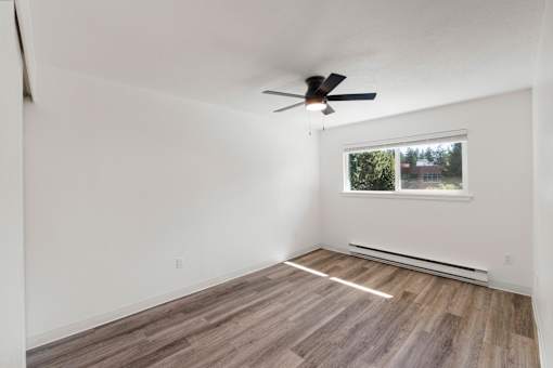 A room with a ceiling fan and a window.