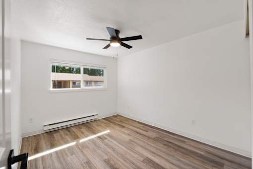 A room with a ceiling fan and a window.