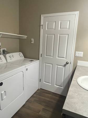 A white bathroom with a toilet, sink, and a door.