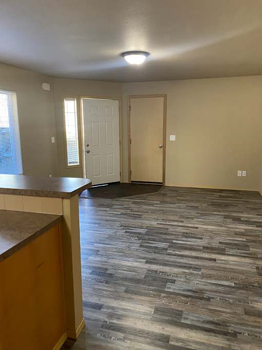 A wooden door with a white frame is in a room with a wooden wall.
