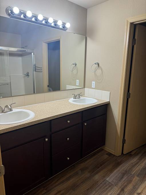 A bathroom with a mirror, sink, and lighting fixture.