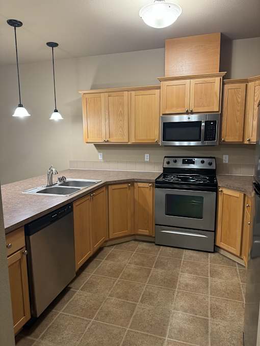 A kitchen with wooden cabinets and black appliances.