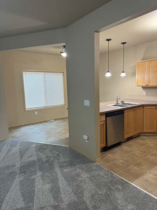 A bathroom with a skylight and a grey tiled wall.