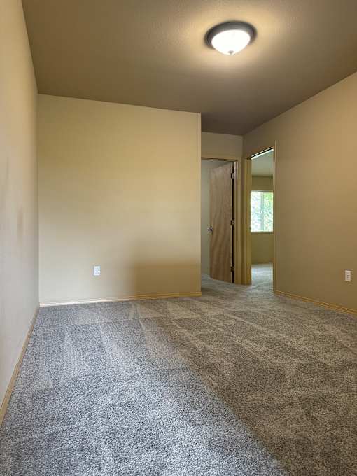 A wall with a circular light fixture on the left side and a textured wall on the right side.