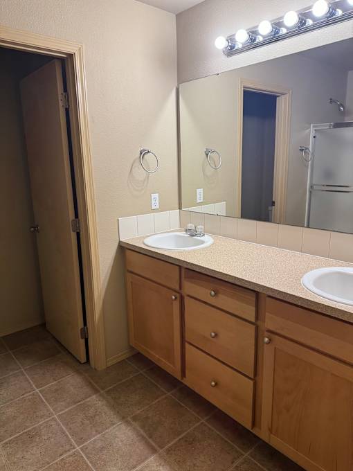 A bathroom with a mirror, light, and a toilet.