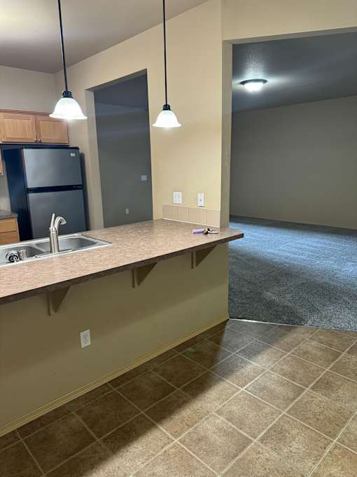 A kitchen with a black fridge and a black oven.