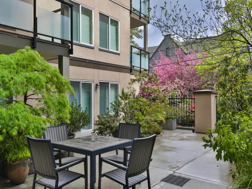 Patio with a table and chairs in front of Charbonneau Apartments in Seattle, WA 98101
