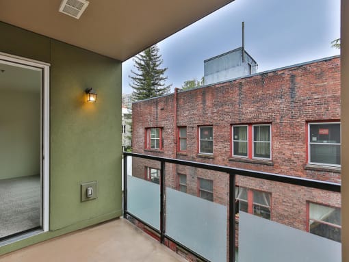 Balcony with a brick building in the background  at Charbonneau Apartments in Seattle, WA 98101