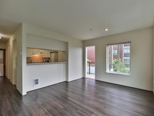 Living room is open to the kitchen and dining room  at Charbonneau Apartments in Seattle, WA 98101