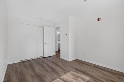 A room with a white door and a wooden floor.